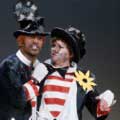 During an appearance on Judy Garland's TV show in 1966, Sammy Davis Jr. and garland are dressed as hobos. This color photo taken by Milton H Greene shows Sammy to Judy's left with his right arm at her oversized bow tie. Sammy is dramatically saying something as Judy looks on with surprise. 