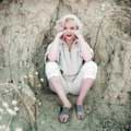 Photographed by Milton H Greene in Laurel Canyon, Los Angeles in 1953 for Look Magazine, Marilyn Monroe is sitting against a rock face and wearing pedal pusher corduroy suit. Exuding strength and self confidence while donning bright red lipstick, Marilyn's sleeves are pushed up and her arms are on her knees and supporting her face.