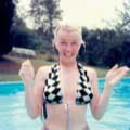 This Milton H Greene image of Marilyn Monroe captures the legendary beauty in a way few have seen her before. Taken in Connecticut in 1956, this image of the young freckle-faced star without makeup reveals her intimate side. Marilyn shows off her black and white checkered bikini bathing suit in the pool. 