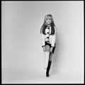 Iconic 1966 black and white photo of Nancy Sinatra standing and pulling up one boot while wearing a black and a white boot. Taken by Milton H Greene during the height of Nancy's hot song 